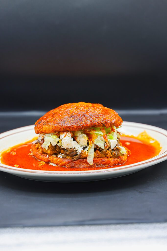 Lettuce, cream, queso, beans, asdaa and chorizo served on soft bread and smothered in red sauce at Super Carniceria.