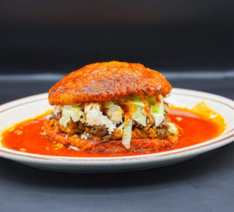Lettuce, cream, queso, beans, asdaa and chorizo served on soft bread and smothered in red sauce at Super Carniceria.