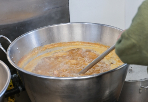 Carnitas in pot being stirred